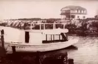 Historic Becker House next to the Florida City Canal, with a canal boat in view